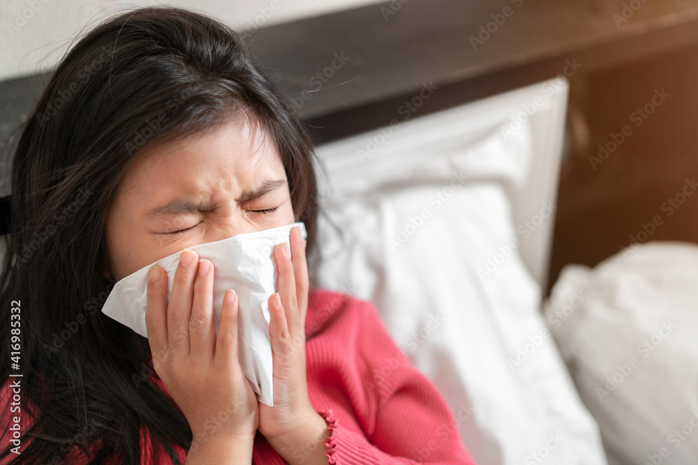 Sick asian girl have hight fever flu and sneezing into tissue on bed in bedroom, Healthcare and prevent the spread infection virus concept, Selective focus. Sick asian girl have hight fever flu and sneezing into tissue on bed in bedroom, Healthcare and prevent the spread infection virus concept, Selective focus.
