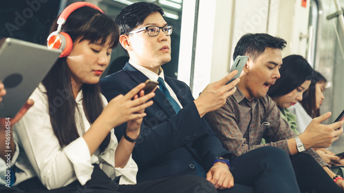 Foto Young people using mobile phone in public underground train