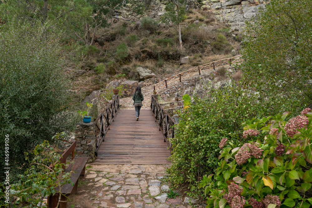 Obraz premium Woman walking on a bridge in Penha Garcia historic village Pego river beach, in Portugal