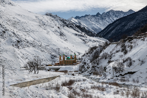 a mosque with green domes at the bottom of a gorge in the mountains of Ingushetia 