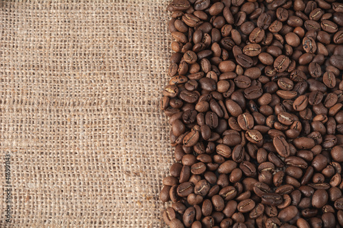 Roasted coffee beans on a jute background with space for your text