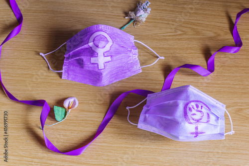 Dos mascarillas desechables para la pandemia del coronavirus Covid-19 con los símbolos y logo del feminismo. Día Internacional de la Mujer, concepto de protestas del 8 de Marzo en la nueva normalidad. photo