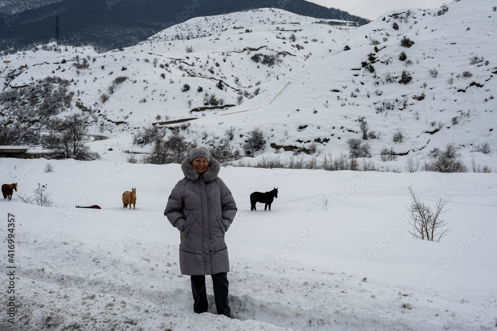 woman in a gray jacket travels in the winter in the Caucasus mountains 