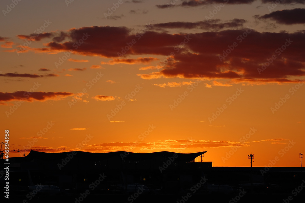 Airport terminal silhouette on sunset sky background