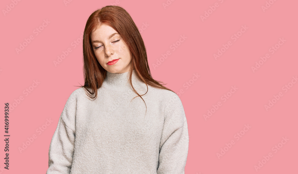 Young read head woman wearing casual winter sweater with serious expression on face. simple and natural looking at the camera.