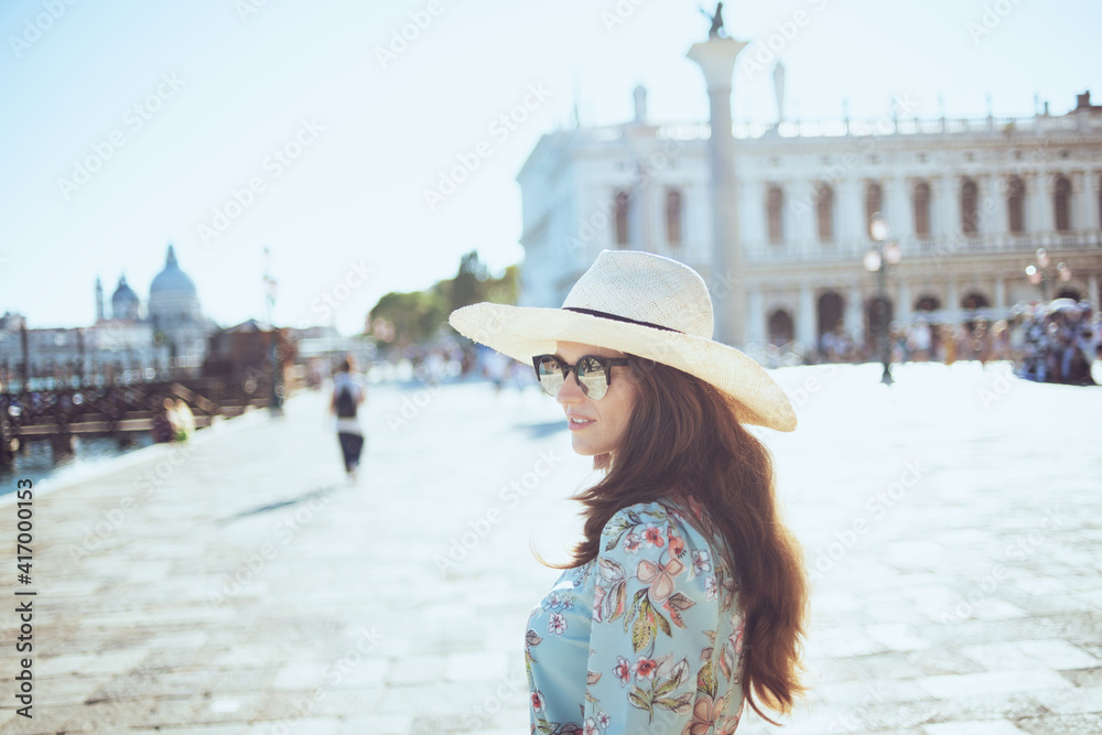 trendy traveller woman in floral dress enjoying promenade