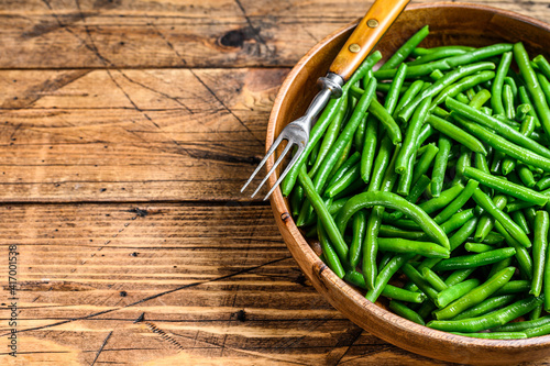 Cooked green beans in a wooden plate. wooden background. top view. Copy space