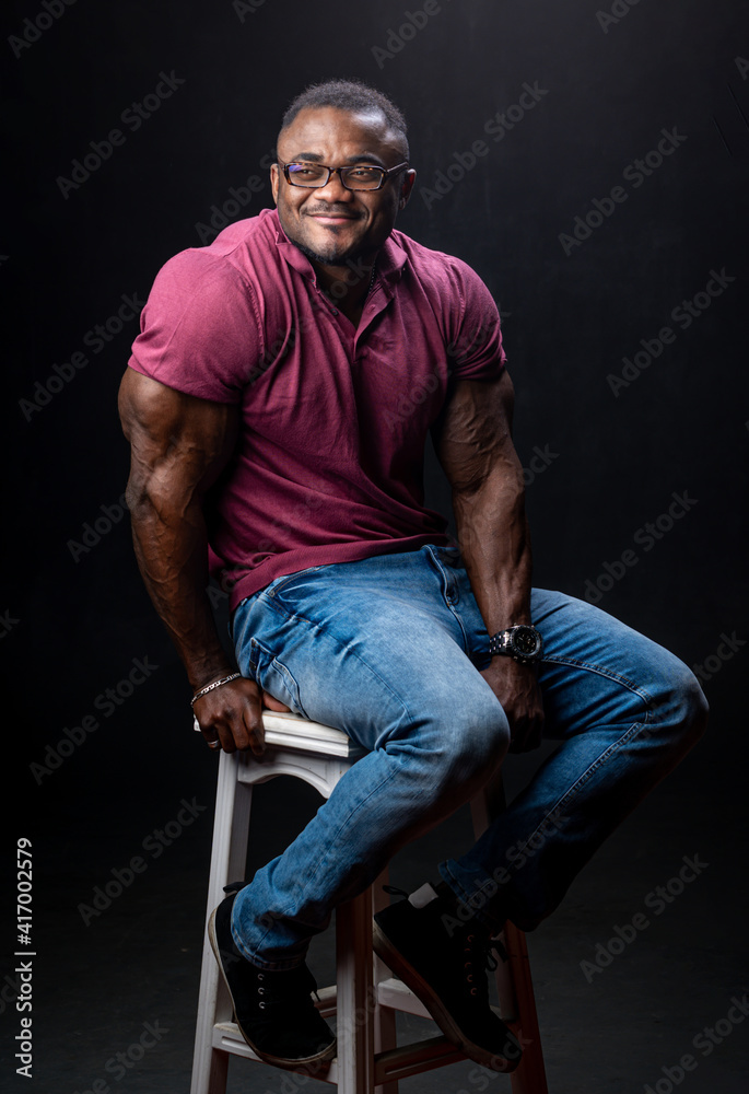 Man portrait. Style. Handsome Afro American guy in glasses is smiling, on a black background Man portrait. Style. Handsome Afro American guy in glasses is smiling, on a black background