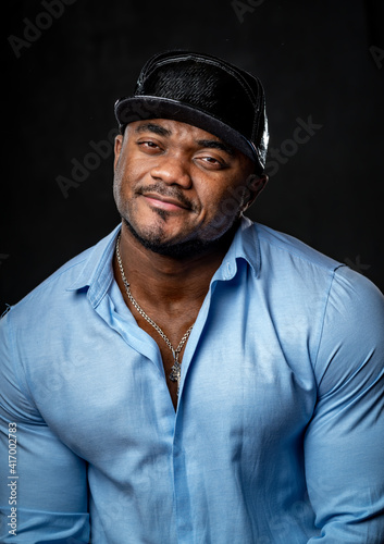 Close up portrait of a handsome young African American businessman smiling in studio with gray background