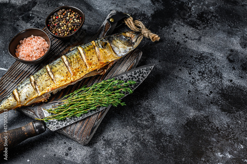 BBQ Grilled mackerel fish with herbs. Black background. Top view. Copy space