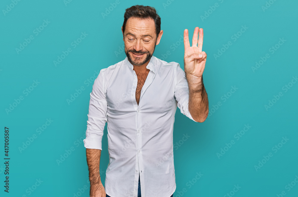 Middle age man wearing casual clothes showing and pointing up with fingers number three while smiling confident and happy. Middle age man wearing casual clothes showing and pointing up with fingers number three while smiling confident and happy.
