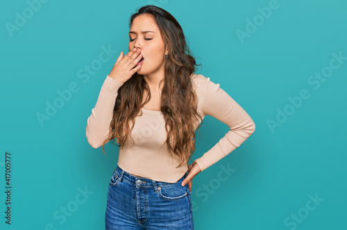 Young hispanic girl wearing casual clothes bored yawning tired covering mouth with hand. restless and sleepiness. © Krakenimages.com