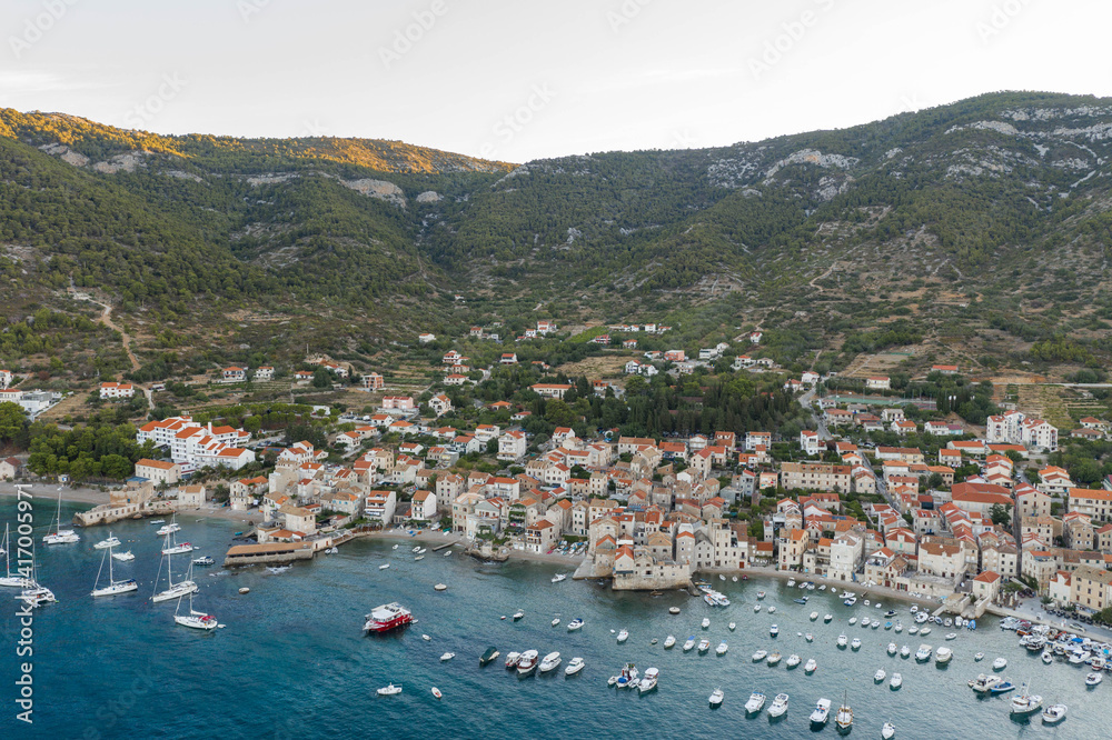 Fototapeta premium Aerial drone shot of Adriatic coastline in Komiza town on Vis Island in summer sunrise