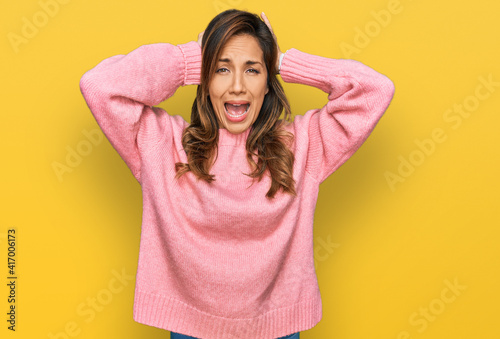 Young hispanic woman wearing casual clothes crazy and scared with hands on head, afraid and surprised of shock with open mouth © Krakenimages.com