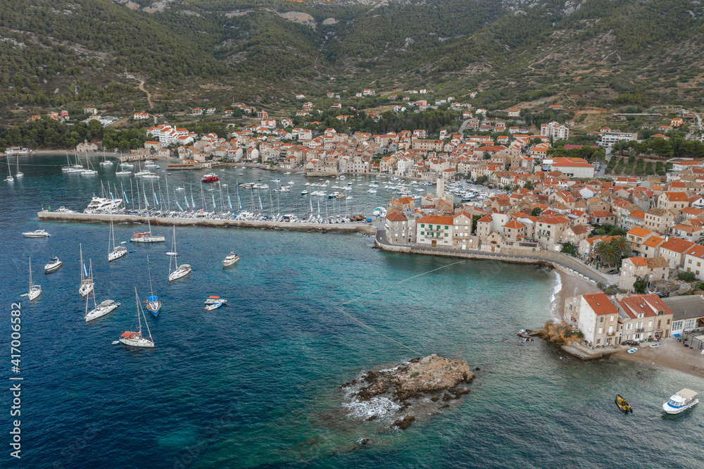Fototapeta premium Aerial drone shot of Adriatic coastline dock by Komiza on Vis Island in morning before sunrise in Croatia summer