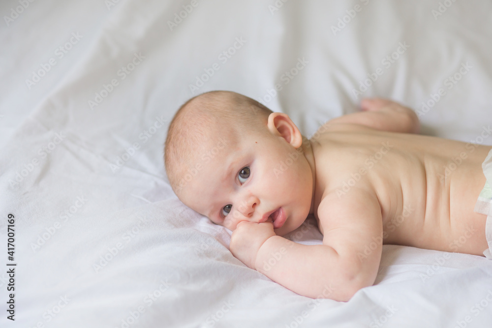 Happy infant girl doing baby massage by his mother at home. Newborn child about 5 months old