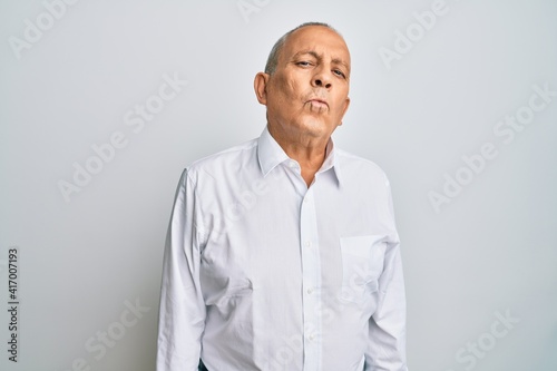 Handsome senior man wearing casual white shirt looking at the camera blowing a kiss on air being lovely and sexy. love expression.