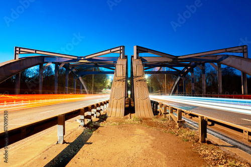 The Hartford Bridge at night, or Blue Bridge, is a single-span road bridge crossing the River Weaver at Hartford, Cheshire in England. The bridge is located on the A556.