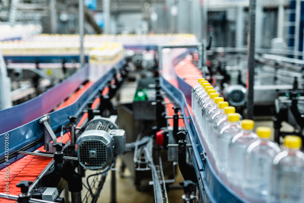 Bottling factory - Juice bottling line for processing and bottling lemon juice into bottles. Selective focus.