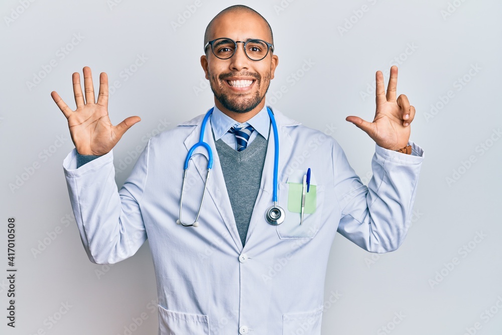 Hispanic adult man wearing doctor uniform and stethoscope showing and pointing up with fingers number eight while smiling confident and happy. Hispanic adult man wearing doctor uniform and stethoscope showing and pointing up with fingers number eight while smiling confident and happy.