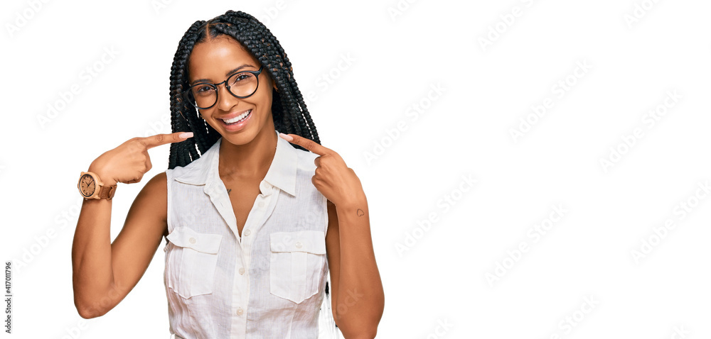 Beautiful hispanic woman wearing casual clothes and glasses smiling cheerful showing and pointing with fingers teeth and mouth. dental health concept. Beautiful hispanic woman wearing casual clothes and glasses smiling cheerful showing and pointing with fingers teeth and mouth. dental health concept.