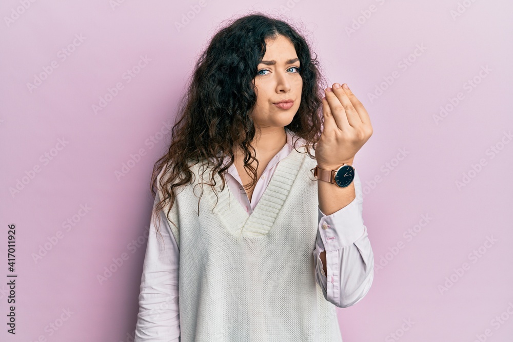 Young brunette woman with curly hair wearing casual clothes doing italian gesture with hand and fingers confident expression Young brunette woman with curly hair wearing casual clothes doing italian gesture with hand and fingers confident expression