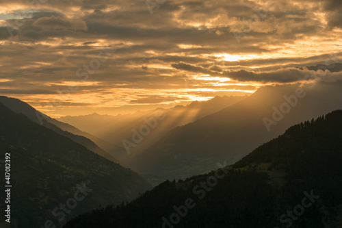 Morgensonne mit Schattenwurf durch die Wolken im Goms