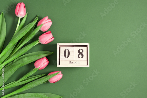 Beautiful pink tulips and calendar on pastel green background. Concept Women's Day, March 8. 8th march. Flat lay, top view, copy space