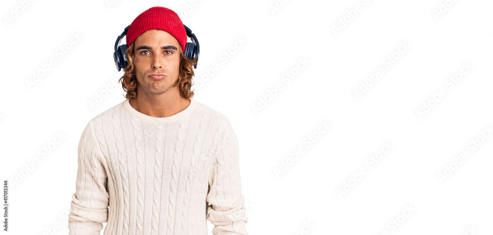 Fototapeta premium Young hispanic man listening to music using headphones depressed and worry for distress, crying angry and afraid. sad expression.