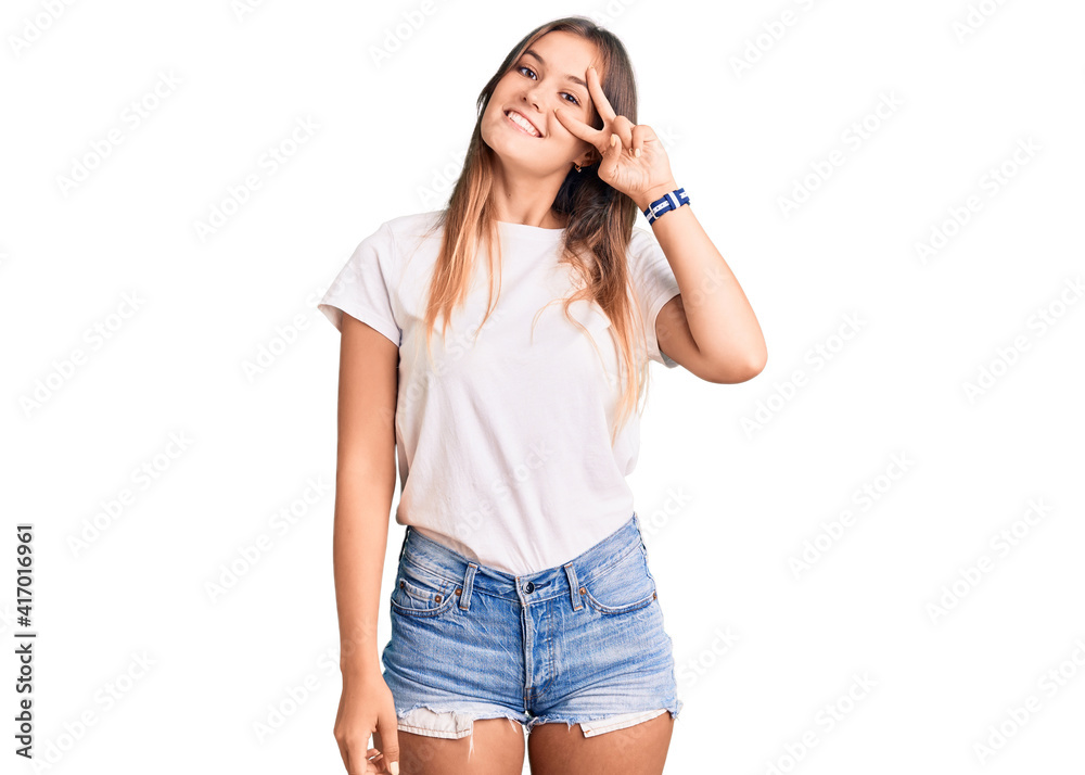 Beautiful caucasian woman wearing casual white tshirt doing peace symbol with fingers over face, smiling cheerful showing victory Beautiful caucasian woman wearing casual white tshirt doing peace symbol with fingers over face, smiling cheerful showing victory