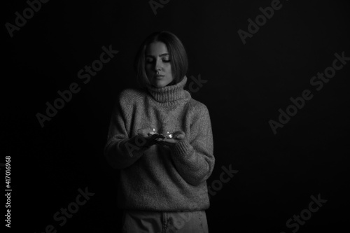 Young woman with two candles in her hands in black and white