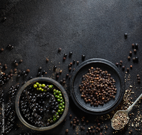 Background with black peppercorns in a dark colors with copy space