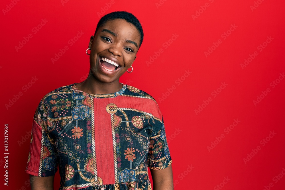 Young african american woman wearing african style winking looking at the camera with sexy expression, cheerful and happy face.