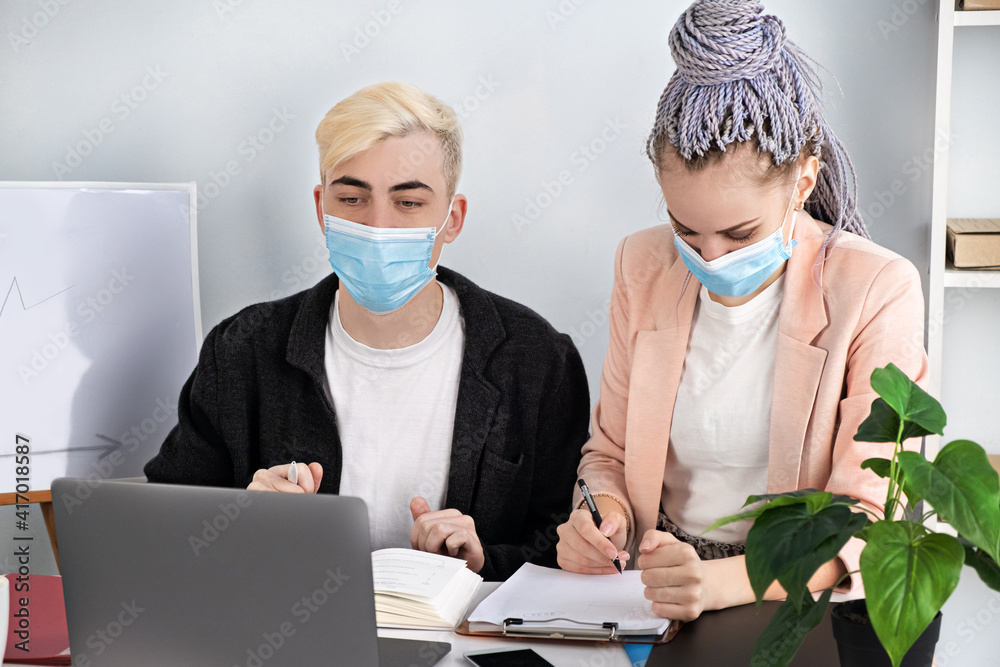 Corporate business, online conference. Young modern people communicate using laptop explaining business development strategy. Successful professional work. Man and woman wearing jackets.