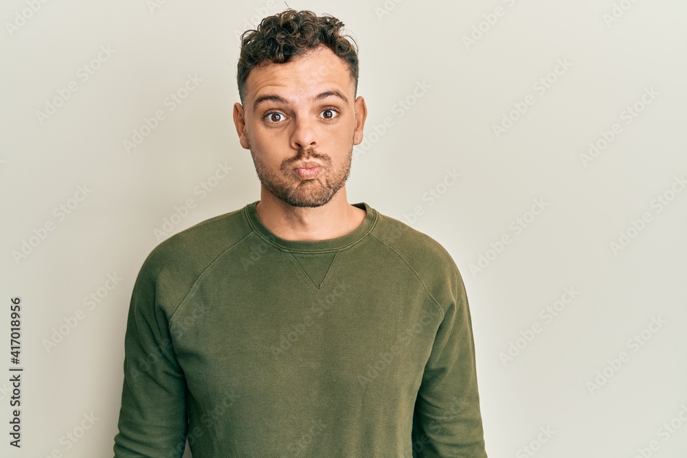 Young hispanic man wearing casual clothes making fish face with lips, crazy and comical gesture. funny expression. Young hispanic man wearing casual clothes making fish face with lips, crazy and comical gesture. funny expression.
