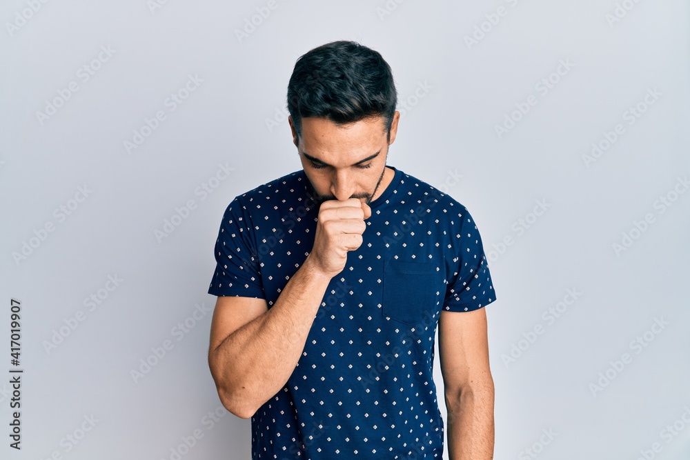 Young hispanic man wearing casual clothes feeling unwell and coughing as symptom for cold or bronchitis. health care concept. Young hispanic man wearing casual clothes feeling unwell and coughing as symptom for cold or bronchitis. health care concept.
