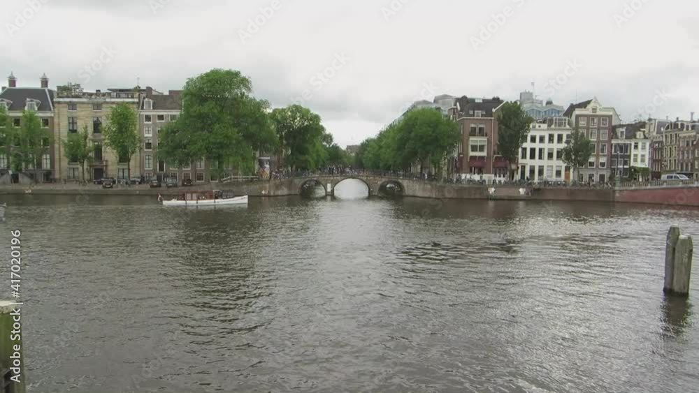 Amsterdam,Netherlands - June 2016: View of the Amstel River and boats, Amsterdam. Amsterdam,Netherlands - June 2016: View of the Amstel River and boats, Amsterdam.