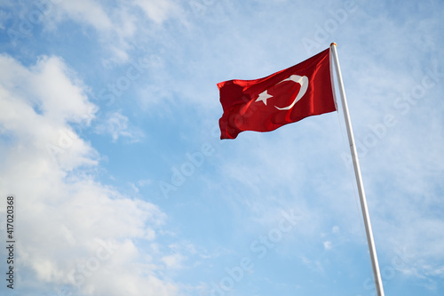 National Turkish flag waving against blue sky.