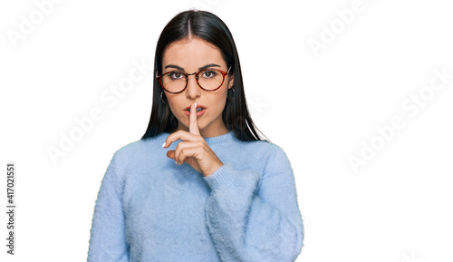 Young hispanic woman wearing casual clothes and glasses asking to be quiet with finger on lips. silence and secret concept.
