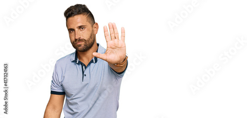 Handsome man with beard wearing casual clothes doing stop sing with palm of the hand. warning expression with negative and serious gesture on the face. © Krakenimages.com