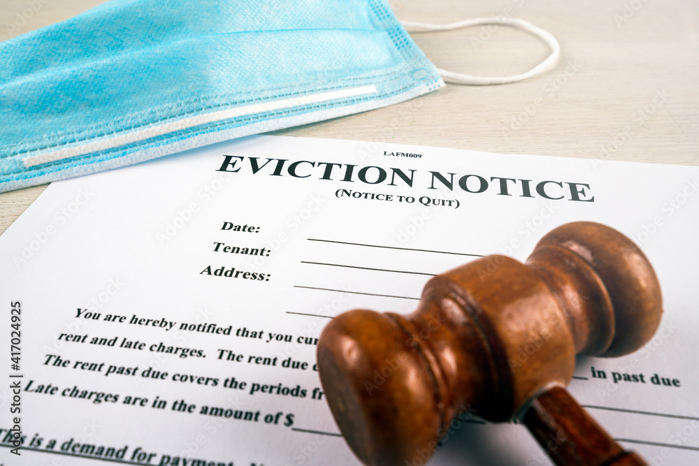 Eviction notice, notice to quit document with facial mask and gavel during covid-19.