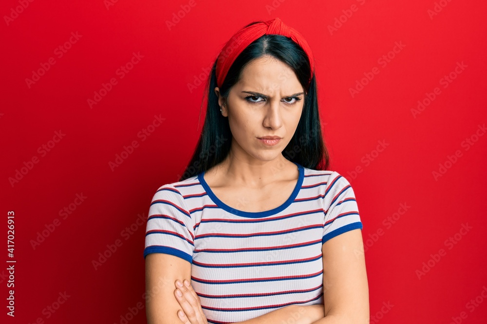 Young hispanic woman wearing casual clothes skeptic and nervous, disapproving expression on face with crossed arms. negative person. Young hispanic woman wearing casual clothes skeptic and nervous, disapproving expression on face with crossed arms. negative person.