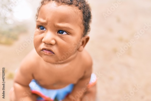 Adorable african american toddler sitting at the beach.