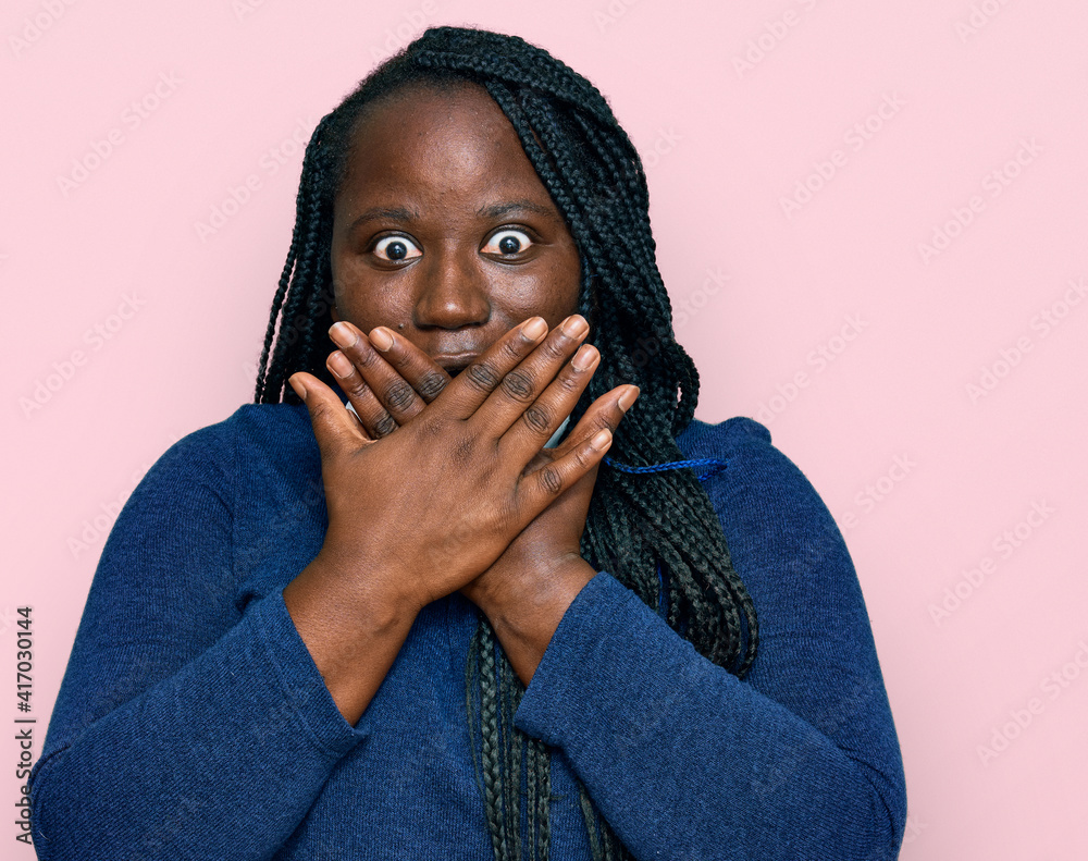 Young black woman with braids wearing casual clothes shocked covering mouth with hands for mistake. secret concept. Young black woman with braids wearing casual clothes shocked covering mouth with hands for mistake. secret concept.