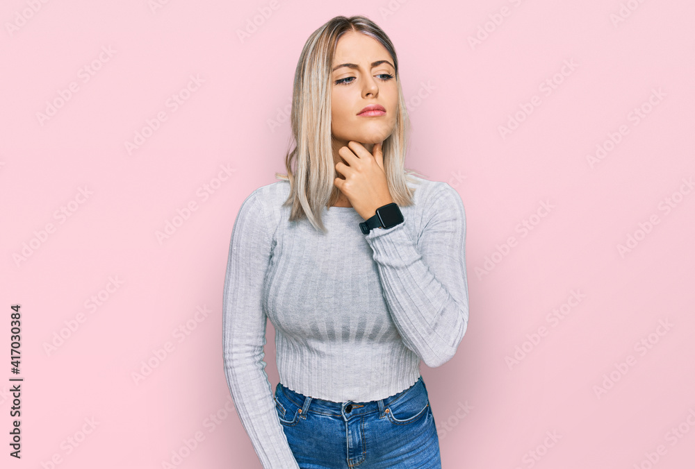 Beautiful blonde woman wearing casual clothes touching painful neck, sore throat for flu, clod and infection Beautiful blonde woman wearing casual clothes touching painful neck, sore throat for flu, clod and infection
