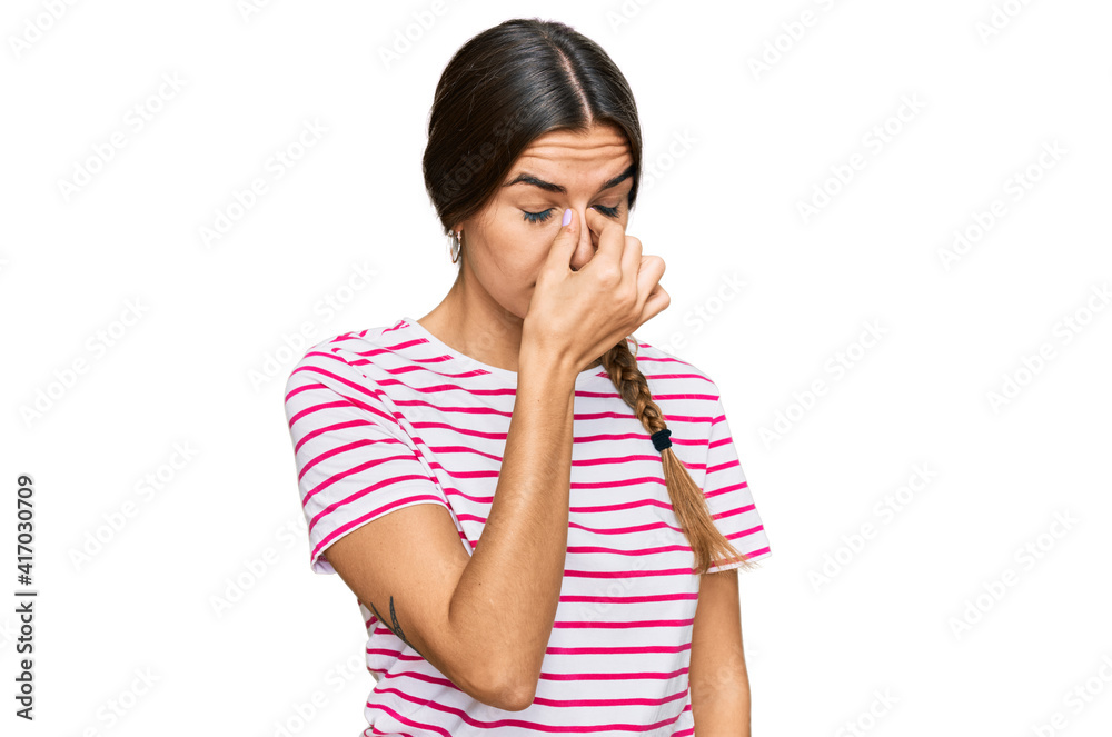 Young hispanic woman wearing casual clothes tired rubbing nose and eyes feeling fatigue and headache. stress and frustration concept. Young hispanic woman wearing casual clothes tired rubbing nose and eyes feeling fatigue and headache. stress and frustration concept.