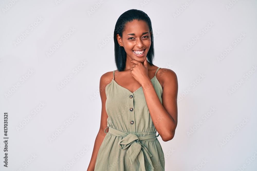 Fototapeta premium Young african american woman wearing casual clothes looking confident at the camera smiling with crossed arms and hand raised on chin. thinking positive.