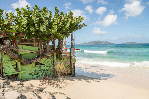 Abandoned shack on the beach at Tortola with St. John mountains in the background.