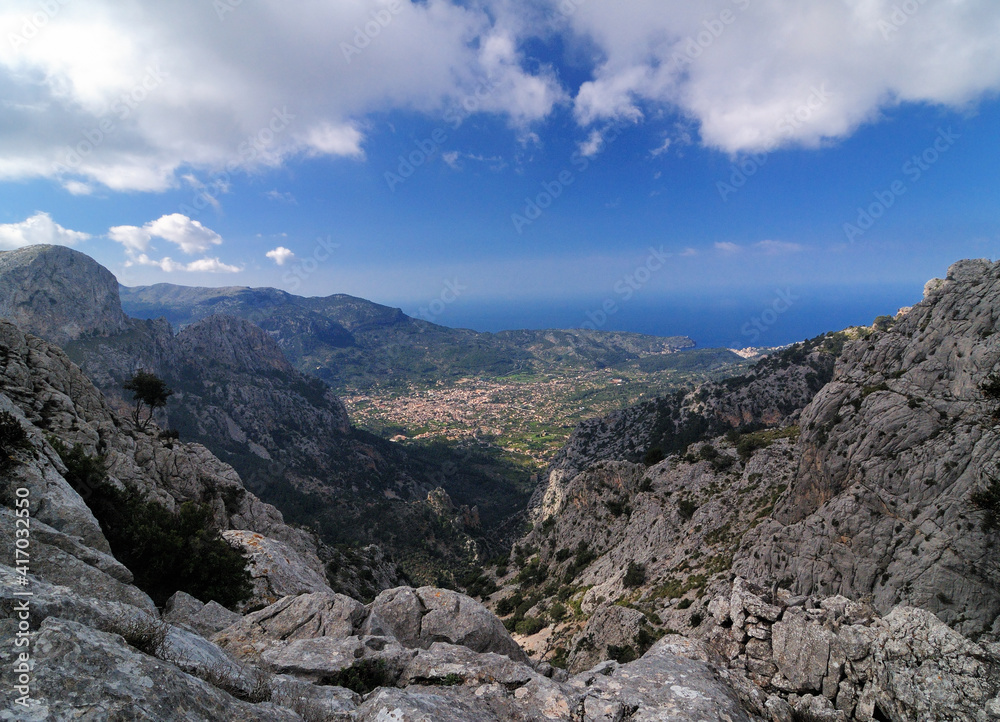 Spectacular View From The Summit Of Mount L'Ofre To The Village Of Soller In The Tramuntana Mountains On Balearic Island Mallorca On A Sunny Winter Day With A Few Clouds In The Blue Sky