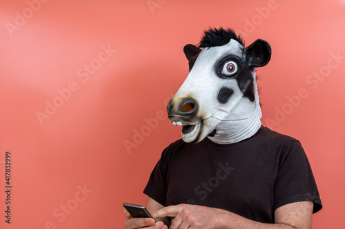 Fotografija person disguised as a cow using a cell phone